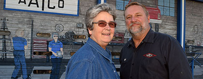 AATCO Transmission owners in front of their Montrose auto repair shop